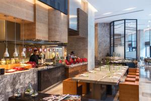 a restaurant with a buffet line with people preparing food at Renaissance Haikou Hotel in Haikou