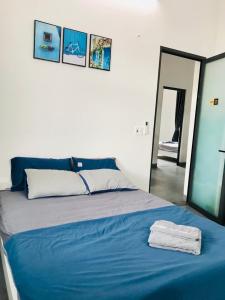 1 dormitorio con cama azul y espejo en Tammy homestay- Ganh Da Dia, en Tuy An