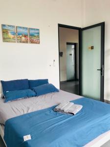 1 dormitorio con 1 cama con sábanas azules y espejo en Tammy homestay- Ganh Da Dia, en Tuy An