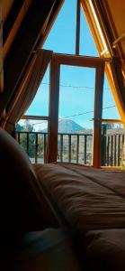 1 dormitorio con ventana grande con vistas a la montaña en Cabin LEHA LEHE SYARIAH Dieng en Dieng