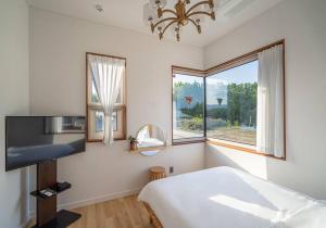 a bedroom with a bed and a large window at Dignitas Luxury Villa in Gangneung