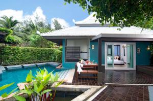 a villa with a swimming pool next to a house at Anyavee Tubkaek Beach Resort in Tab Kaek Beach