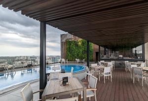 a patio with tables and chairs and a pool at The Peninsula Chittagong Limited in Chittagong