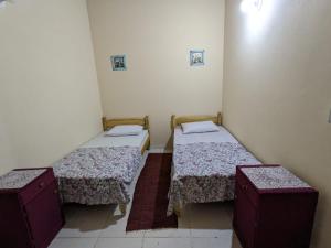 a room with two beds and two tables in it at Cómoda casa independiente in Capiatá