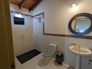 een badkamer met een wastafel, een toilet en een spiegel bij Cómoda casa independiente in Capiatá