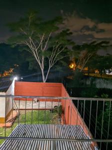 a fence with a tree in the background at night at Cómoda casa independiente in Capiatá