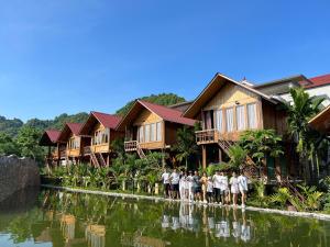 a group of people standing in front of houses at Phong Nha Mountain House in Vực Trô