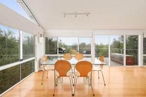 a dining room with a glass table and chairs at Modern Sanctuary by the Silverleaves Beach in Rhyll