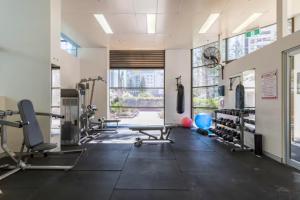 a gym with treadmills and machines and a large window at Longbeach Luxe, Surfers Paradise in Gold Coast