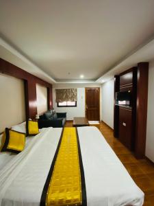 a large bed in a hotel room with a yellow stripe at Lacasa Vang Vieng Hotel in Vang Vieng