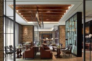 a restaurant with tables and chairs and brick walls at The Ritz-Carlton, Haikou in Haikou
