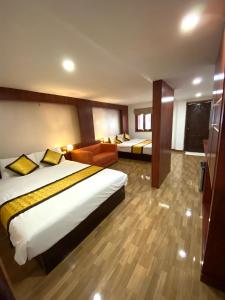 a hotel room with two beds and a couch at Lacasa Vang Vieng Hotel in Vang Vieng