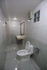a bathroom with a toilet with a sink and a mirror at Lacasa Vang Vieng Hotel in Vang Vieng