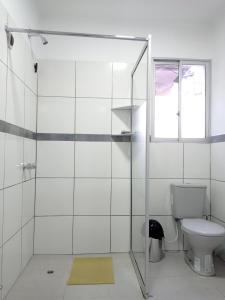 a white bathroom with a toilet and a window at Apartamento Privado SOL in Tarija