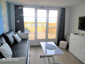 d'un salon avec un canapé et une table ainsi que d'un balcon. dans l'établissement DIVINE MARINA vue mer - Piscines, à Dives-sur-Mer