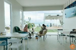 a group of people sitting in a room with a view of the ocean at Miami Seaview in Ban Pak Ba Ra