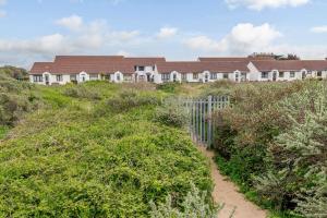 a house on the top of a hill with bushes at Ocean Breeze in Burnham on Sea