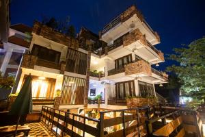 a house with a fence in front of it at night at Cambana d'Angkor Suites in Siem Reap