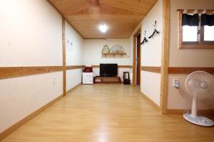 pasillo de una habitación con ventilador y TV en Moran Guesthouse en Jeonju