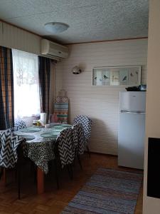 RistiinaにあるRistiina Apartment with Saunaのキッチン(テーブル、椅子、冷蔵庫付)