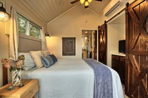1 dormitorio con 1 cama grande y puerta de madera en Tiny house near waterfall hikes, en Flat Rock