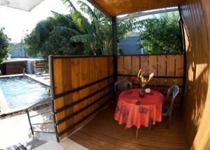 un tavolo e sedie su una terrazza in legno con piscina di le raphael ( chambre piscine) a Saint-Joseph