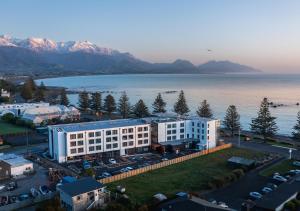 - une vue aérienne sur un grand bâtiment blanc à côté de l'eau dans l'établissement Sudima Kaikōura, à Kaikoura