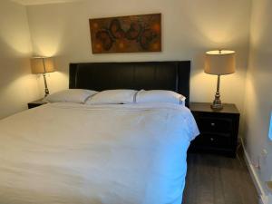 1 dormitorio con 1 cama grande y 2 lámparas en Cosy country mobile home on 18 acres farm sleeps 5, en Port Alberni