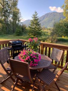 a table with flowers on a deck with a grill at Cosy country mobile home on 18 acres farm sleeps 5 in Port Alberni