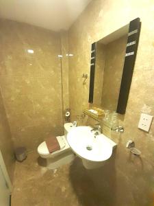 a bathroom with a sink and a toilet and a mirror at Bayview Hotel & Apartments in Vung Tau