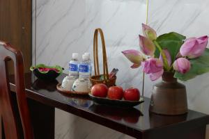 una mesa con un jarrón de flores y botellas de agua en MH Hanoi Hotel, en Hanói