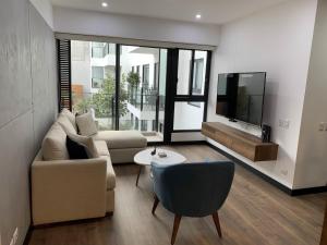 sala de estar con sofá y TV en Executive Apartments San Isidro Business Zone en Lima