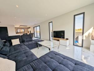 sala de estar con sofá grande y TV en Le Petit Dubaï, en Saint-Jean-Lasseille