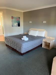 um quarto com uma cama num quarto com em Forster Palms Motel em Forster