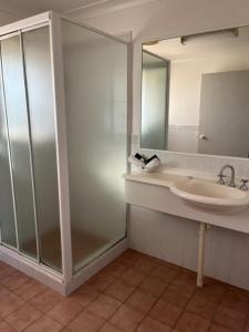 a bathroom with a sink and a mirror at Forster Palms Motel in Forster