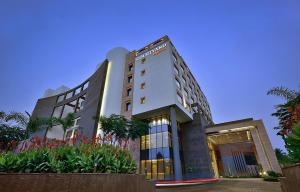 a hotel building with flowers in front of it at Courtyard by Marriott Raipur in Raipur