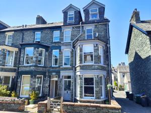 a large brick house with white windows on a street at Squirrel Lodge in Keswick