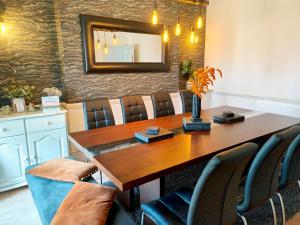 a dining room table with chairs and a mirror at Squirrel Lodge in Keswick