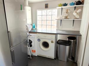 a kitchen with a refrigerator and a washing machine at Squirrel Lodge in Keswick