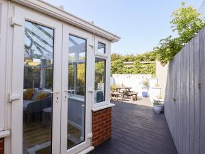 a conservatory with glass doors on a patio at Pond Farm View in Saltburn-by-the-Sea