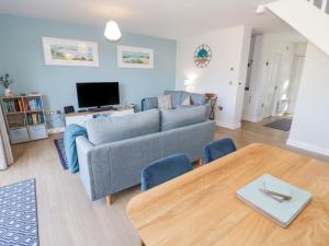 a living room with a couch and a table at 14 Parc Delfryn in Brynteg