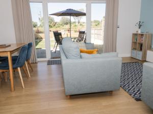 a living room with a chair and a table with an umbrella at 14 Parc Delfryn in Brynteg