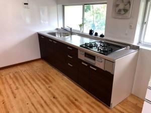 an empty kitchen with a stove and a sink at BEACH HOUSE OHAMA in Kuranomoto