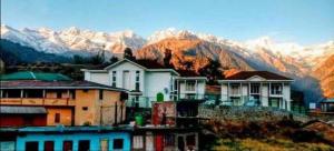 eine Gruppe von Häusern mit Bergen im Hintergrund in der Unterkunft Shri Narayan Tourist lodge & Chandica hotel in Trijugi Nārāyan