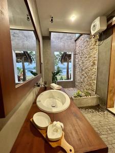 La salle de bains est pourvue d'un lavabo et d'une grande fenêtre. dans l'établissement Shiva Sunrise Resort, à Hikkaduwa