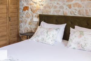 a bedroom with a bed with white sheets and pillows at PORT - unique apartment in Dubrovnik