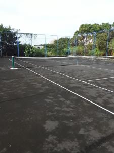 un campo da tennis con una rete di Aquamarine - Grand Baie - 3 chambres - Piscine a Grand Baie