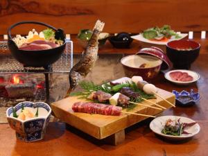 einen Tisch voller Lebensmittel mit Fleisch und anderen Lebensmitteln in der Unterkunft Minshuku Sawaguchi in Agematsu