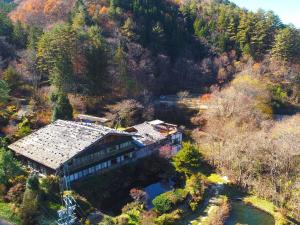 eine Luftansicht eines Hauses in einem Wald in der Unterkunft Minshuku Sawaguchi in Agematsu