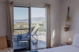 1 dormitorio con 1 cama y balcón con vistas. en Seymour Waves ~ Absolute Serenity, en Bicheno